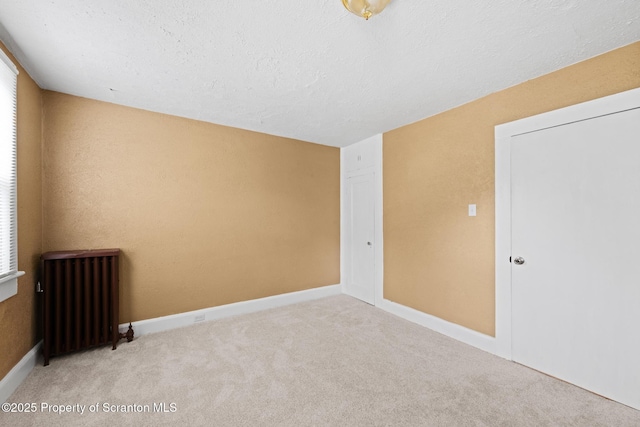 2211 Myrtle St, Scranton, PA 18510 - empty room featuring radiator heating unit, carpet floors, plenty of natural light, and a textured ceiling