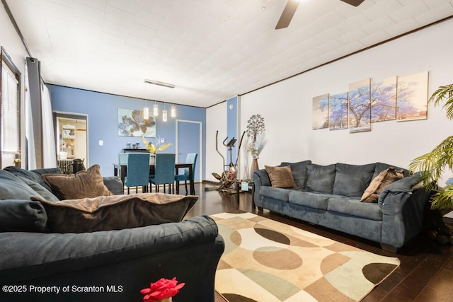 living area with visible vents, ceiling fan, and wood finished floors