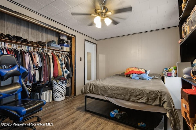 bedroom with ceiling fan, a closet, and wood finished floors