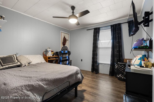 bedroom with crown molding, ceiling fan, and wood finished floors