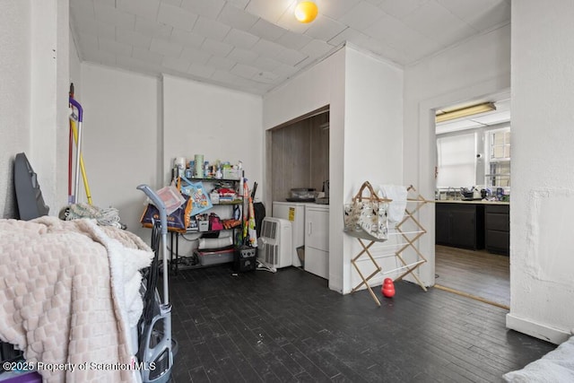 bedroom with dark wood-type flooring and washer and clothes dryer