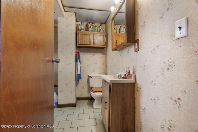 bathroom with wallpapered walls, baseboards, toilet, tile patterned flooring, and vanity