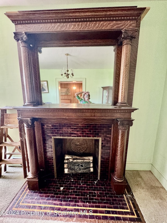 room details with carpet flooring, a tile fireplace, and a notable chandelier