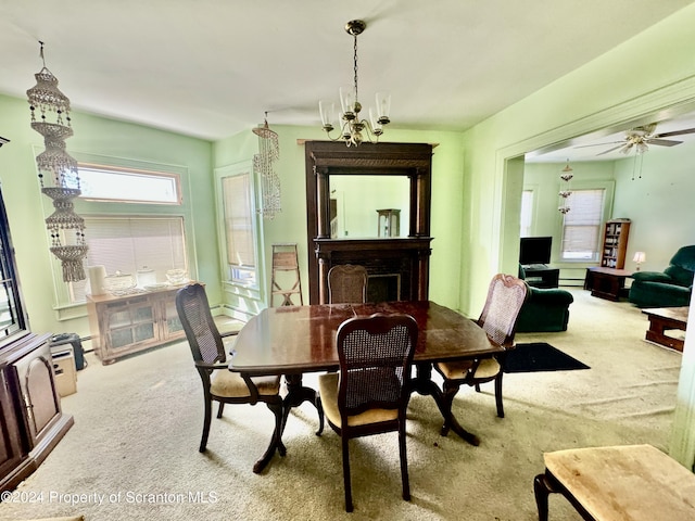 dining space with light carpet, baseboard heating, and ceiling fan with notable chandelier