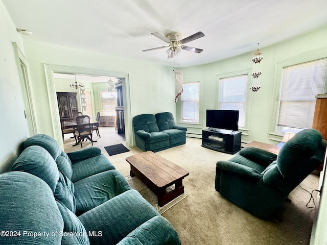 carpeted living room with ceiling fan with notable chandelier and baseboard heating