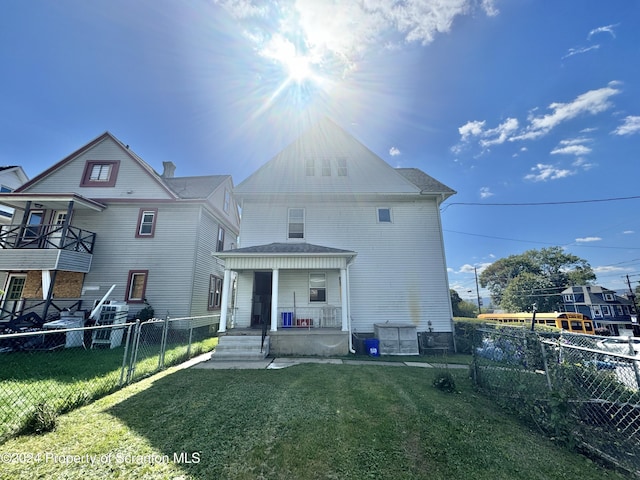 view of front facade featuring covered porch, a fenced front yard, and a front yard