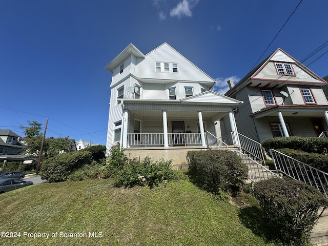 view of front facade featuring covered porch and a front lawn