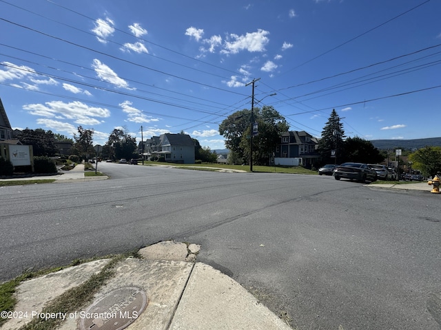 view of street featuring sidewalks, street lighting, and curbs