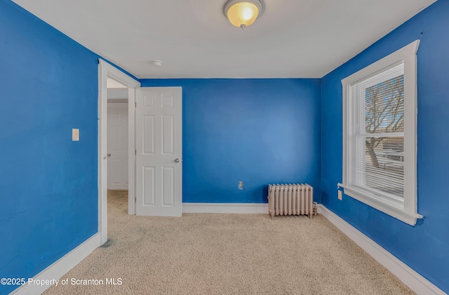 unfurnished bedroom featuring light colored carpet and radiator