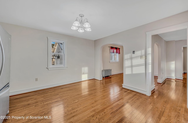 interior space featuring radiator heating unit, a chandelier, and light hardwood / wood-style floors