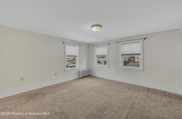 carpeted spare room featuring radiator heating unit