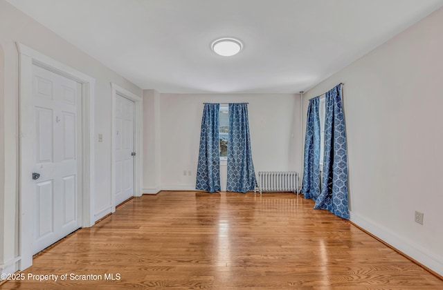 unfurnished bedroom featuring radiator and light wood-type flooring