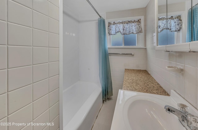 bathroom featuring shower / tub combo, sink, and tile walls