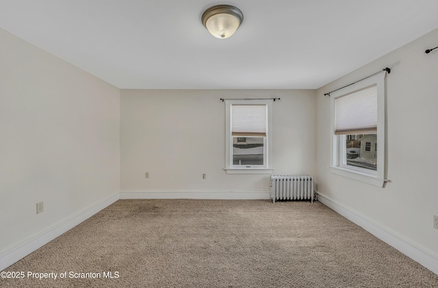 spare room with radiator heating unit and carpet flooring