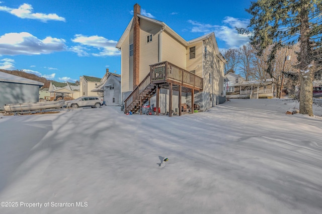 snow covered property with a wooden deck