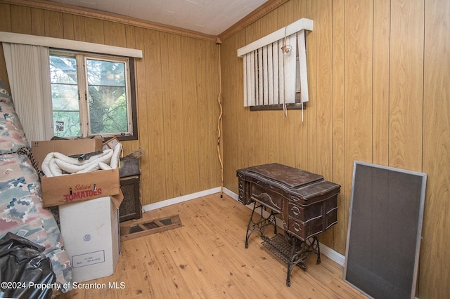 interior space featuring hardwood / wood-style floors, ornamental molding, and wooden walls