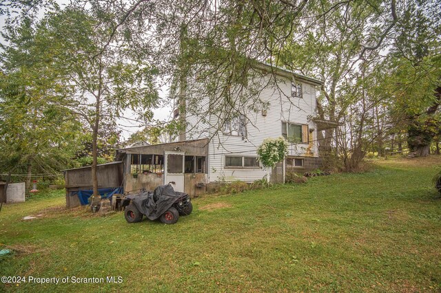 back of property featuring a yard and a sunroom