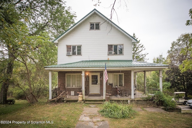 view of front facade featuring covered porch and a front yard