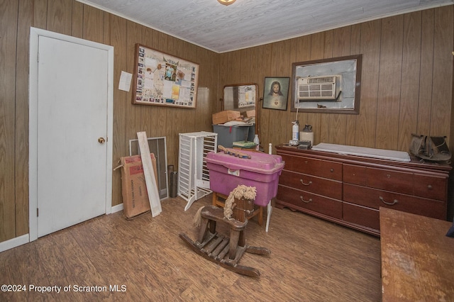 miscellaneous room with cooling unit, wood-type flooring, crown molding, and wooden walls