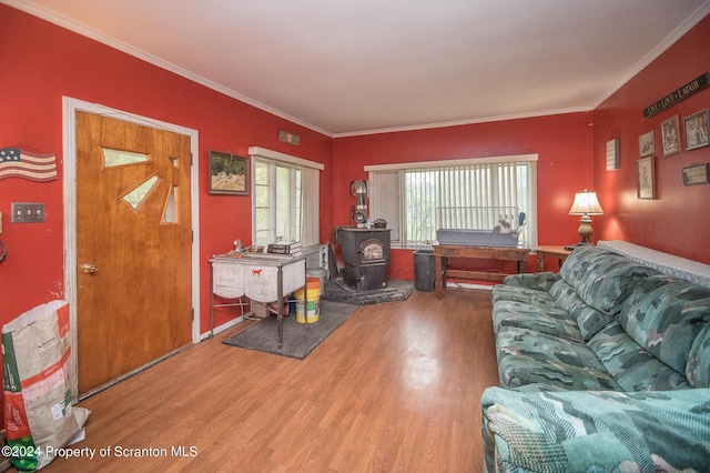 living room with hardwood / wood-style floors, a wood stove, and crown molding