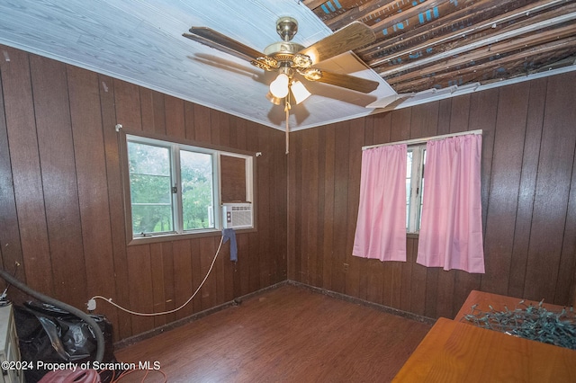 interior space with ceiling fan, dark hardwood / wood-style floors, wood walls, cooling unit, and ornamental molding