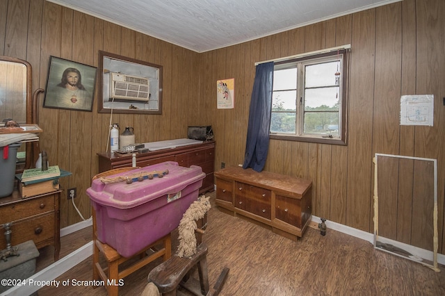 home office featuring wood walls, crown molding, cooling unit, and hardwood / wood-style flooring