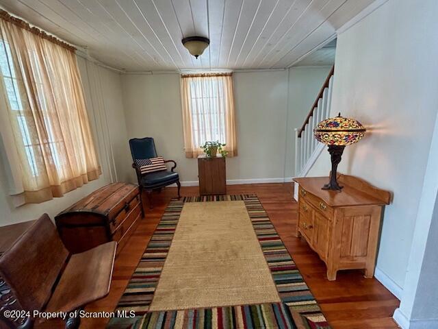 sitting room featuring dark wood-type flooring and wood ceiling