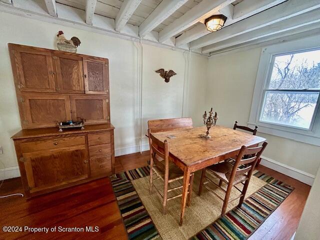 dining area featuring beamed ceiling, wood ceiling, and dark hardwood / wood-style floors