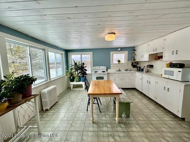 kitchen featuring radiator, white cabinetry, sink, wooden ceiling, and white appliances