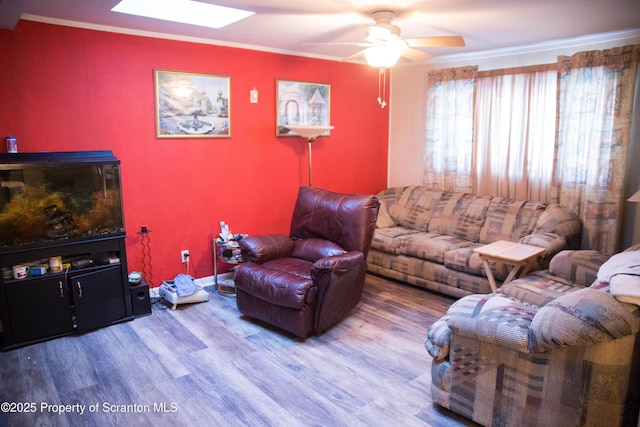 living room with a skylight, wood-type flooring, and ceiling fan