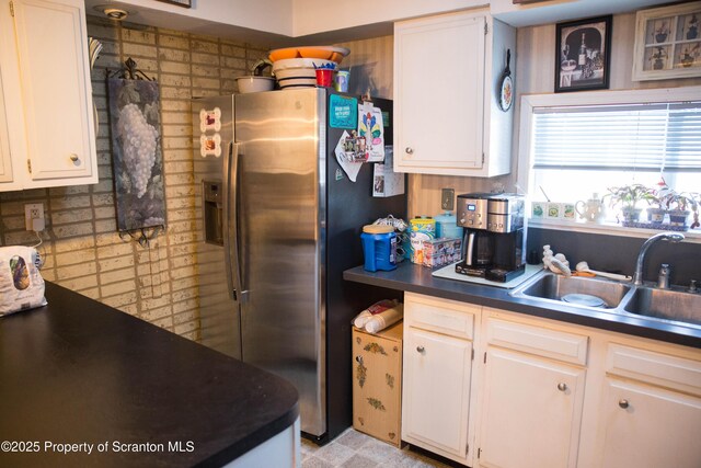 kitchen featuring white cabinetry, sink, and stainless steel refrigerator with ice dispenser