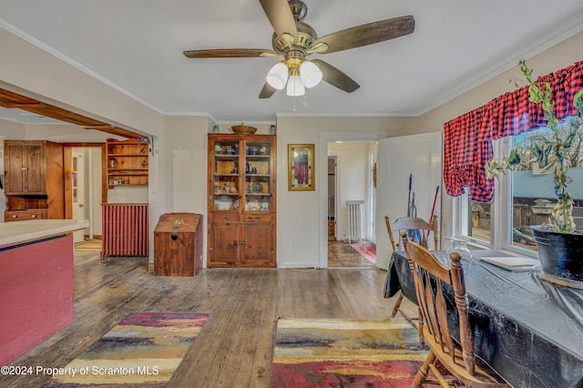 dining area with dark hardwood / wood-style floors, ceiling fan, and ornamental molding