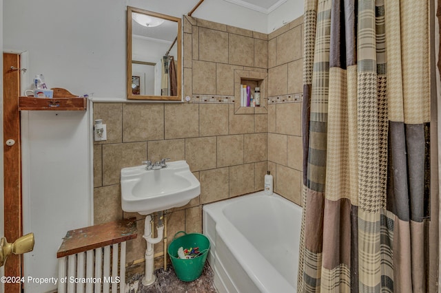 bathroom with decorative backsplash, tile walls, crown molding, and sink