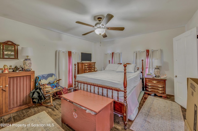 bedroom with dark hardwood / wood-style flooring and ceiling fan