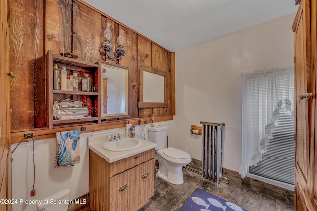 bathroom featuring hardwood / wood-style flooring, vanity, toilet, and radiator