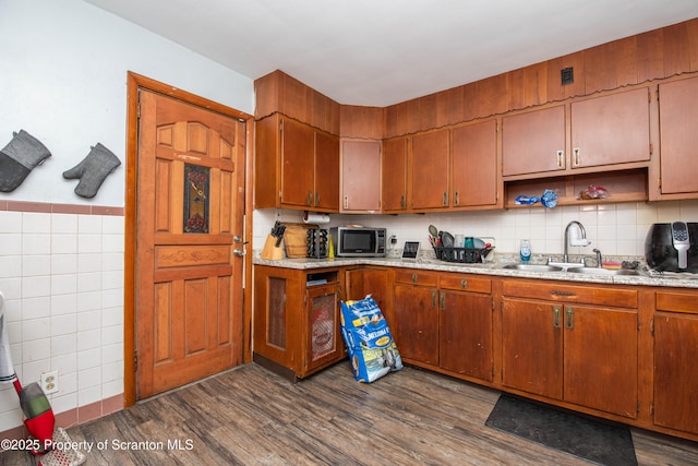 kitchen with dark wood-style floors, light countertops, open shelves, a sink, and stainless steel microwave