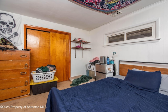 bedroom with carpet floors, visible vents, and a closet