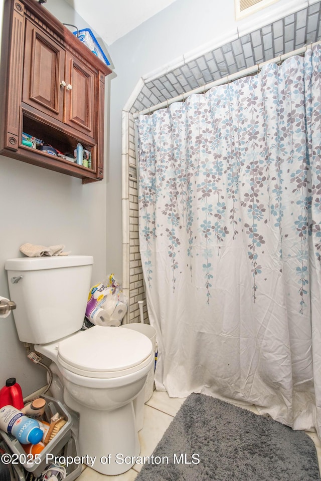 full bath with tile patterned floors, a shower with shower curtain, and toilet