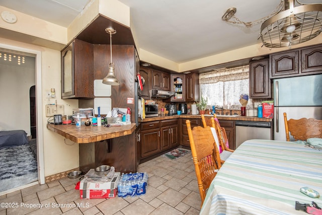 kitchen with dark brown cabinets, appliances with stainless steel finishes, under cabinet range hood, and a sink