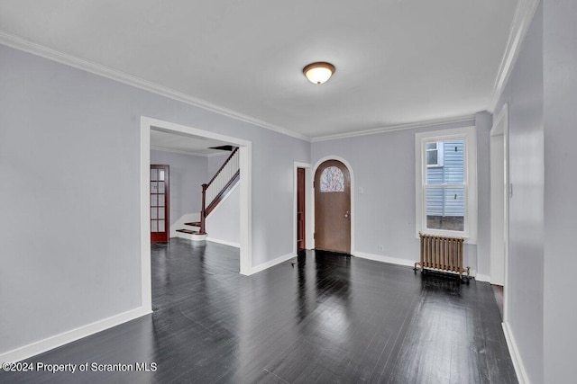 spare room with crown molding, radiator, and dark wood-type flooring