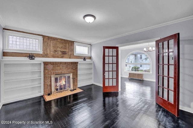 living room featuring french doors, radiator, crown molding, built in features, and a fireplace