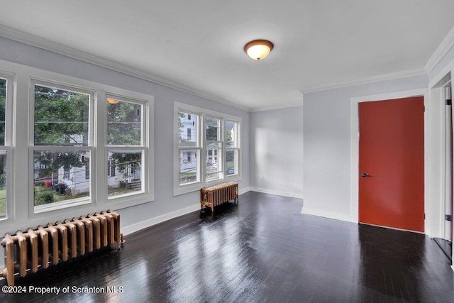 unfurnished room with radiator heating unit, dark hardwood / wood-style floors, and ornamental molding