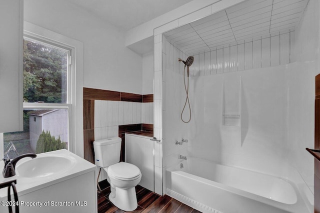 full bathroom featuring vanity, tiled shower / bath combo, and toilet