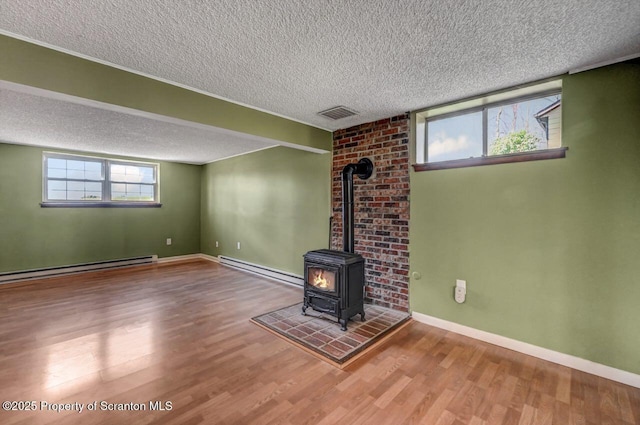 unfurnished living room with a baseboard radiator, wood finished floors, and a textured ceiling
