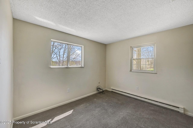 empty room with a textured ceiling, baseboards, a baseboard heating unit, and carpet floors