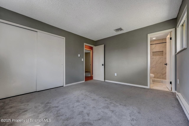 unfurnished bedroom featuring a textured ceiling, carpet flooring, a baseboard radiator, a closet, and baseboards