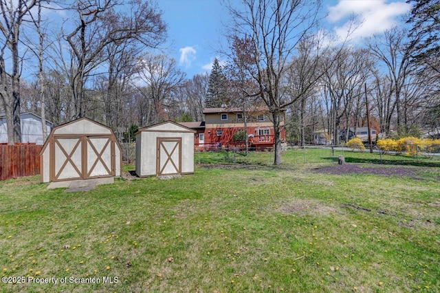 view of yard with fence, an outdoor structure, and a shed