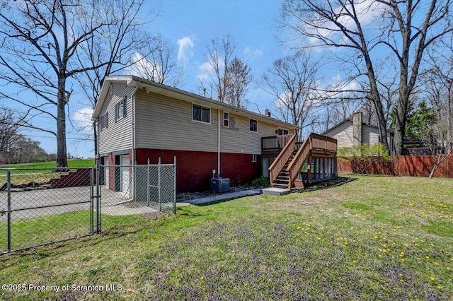back of house with stairway, fence private yard, a gate, a lawn, and a deck