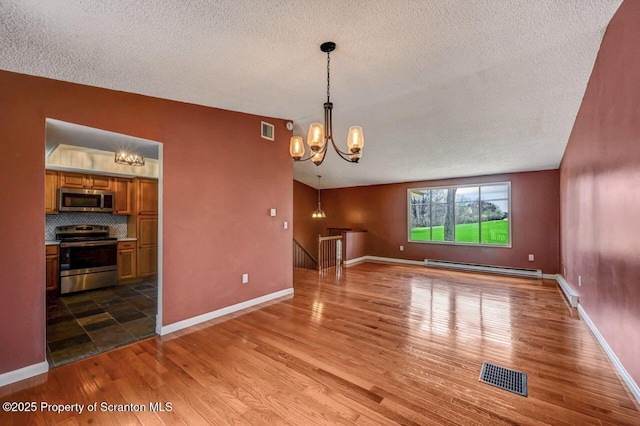 unfurnished dining area featuring an inviting chandelier, a baseboard radiator, visible vents, and a textured ceiling