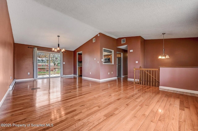 unfurnished living room with a chandelier, wood finished floors, visible vents, baseboard heating, and lofted ceiling
